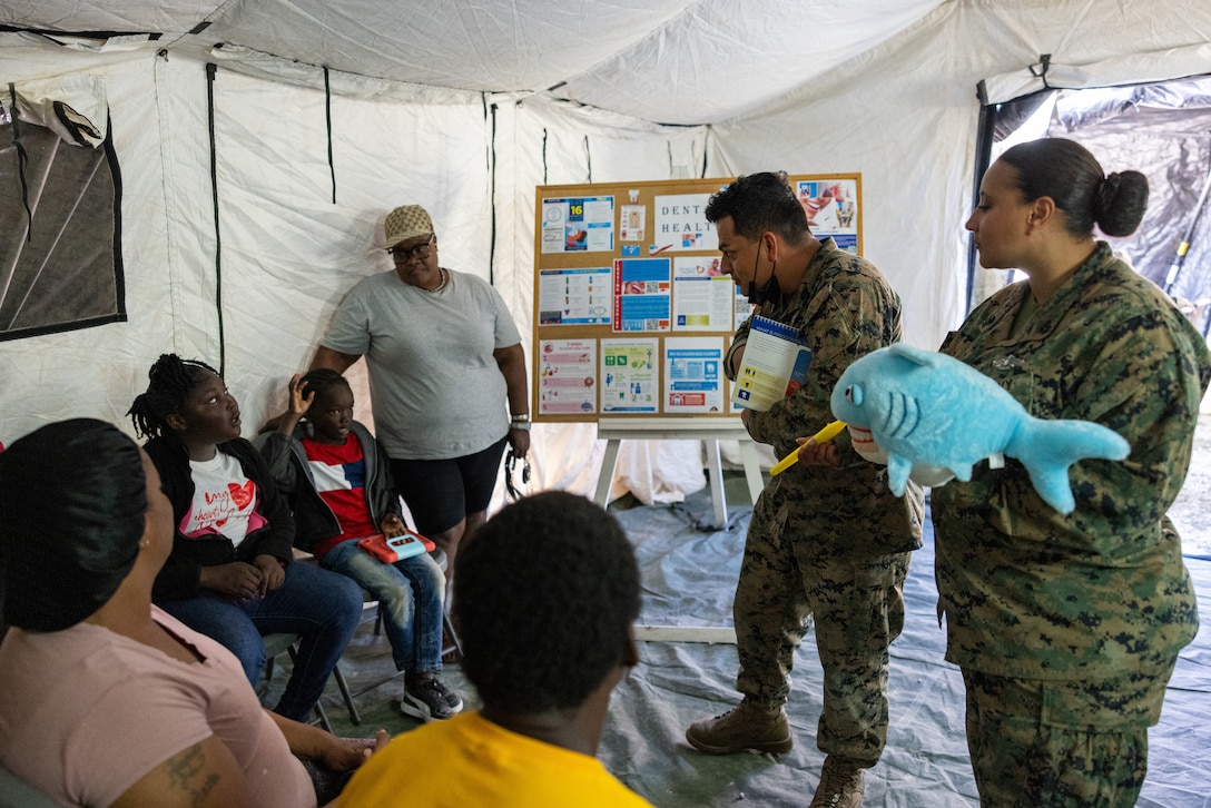 U.S. Navy Hospital Corpsman Petty Officer 3rd Class Anderson Marin, left, from Virginia, a dental corpsman, and Hospital Corpsman Chief Petty Officer Regina Thomas, from Texas, an advanced dental laboratory technician, both with 2nd Dental Battalion, 2nd Marine Logistics Group, and attached to Marine Wing Support Squadron (MWSS) 272, provide information on dental health to Bahamian patients in Coakley Town, Bahamas, Feb. 26, 2025. MWSS-272 deployed to The Bahamas to conduct aviation ground support rehearsals and refine distributed aviation operations for 2nd Marine Aircraft Wing. (U.S. Marine Corps photo by Lance Cpl. Orlanys Diaz Figueroa)