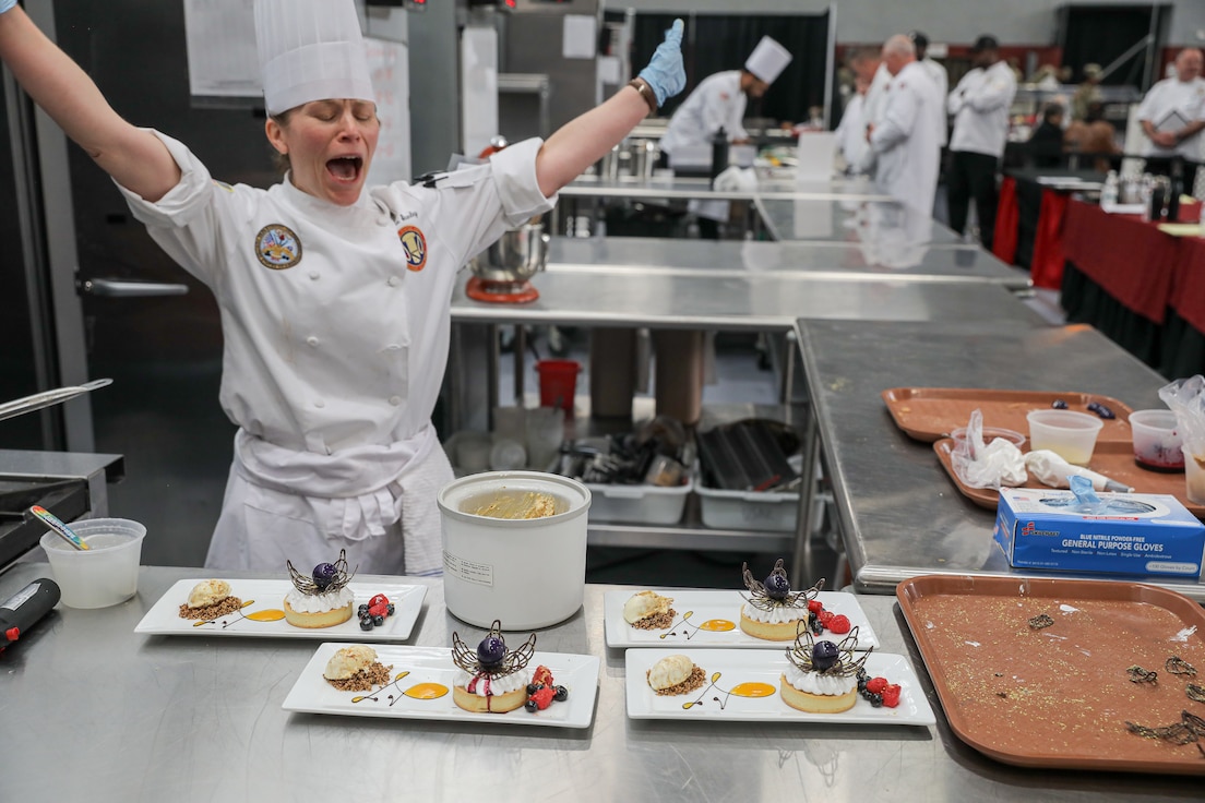 Chief Warrant Officer 2 Christine Stanley, U.S. Army Culinary Arts Team, 364th Sustainment Command (Expeditionary), celebrates after completing the pastry event for Team USA at the 49th Joint Culinary Training Exercise held at Fort Gregg-Adams, Virginia, March 3rd 2025. International Teams representing France, Great Britain, Germany and USA compete in various categories from pastry to hot food challenges to determine which International Team wins.