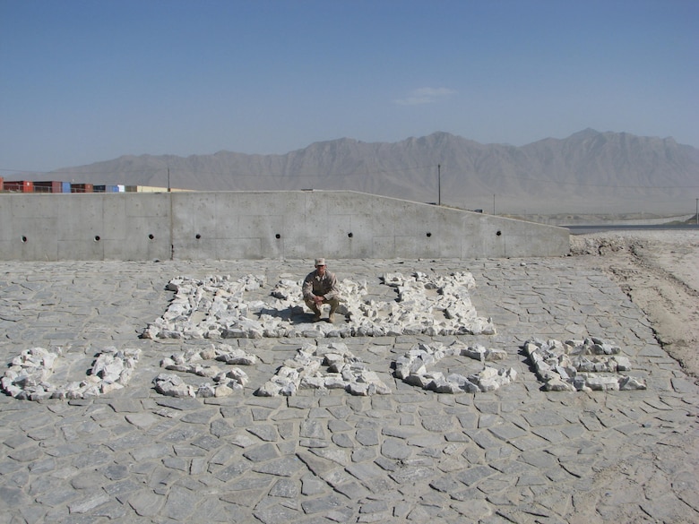 r Roger Vogler poses for a photo on an Army Corps of Engineers rock display.