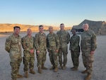 Capt. David Porter (second from left), Sgt. 1st Class Christina McDermott (second from right) and Maj. Will Cochrane (far right), pose with Soldiers from the 1st Infantry Division chaplain section in January 2025 at the National Training Center at Fort Irwin, California. The three Virginia National Guard Soldiers provided chaplain support to the Fort Riley- based 1st Infantry Division during its NTC training rotation Jan. 17- 31, 2025.