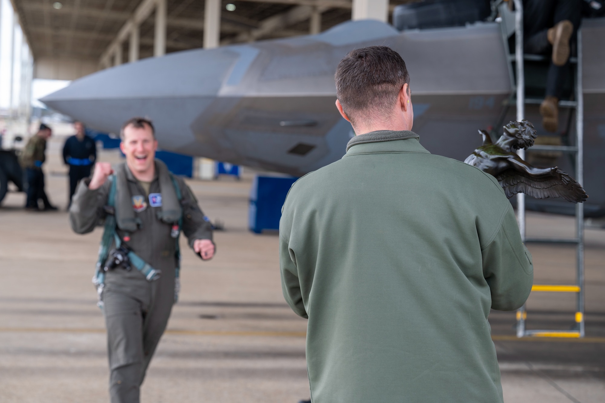 LANGLEY AIR FORCE BASE, Va. – Col. Brandon Tellez, 1st Fighter Wing commander prepares to present the John L. Mitchell Trophy to Lt. Col. Devil 94th Fighter Squadron commander, as he celebrates after being the first competitor to complete the Mitchell Trophy Air Race  at Langley Air Force Base, Virginia,  Mar. 7, 2025.  Devil and the other competitors were required to land, park, refuel and launch their own aircraft. In addition to this the competitors were also required to run 1.6 miles to the Selfridge Air National Guard Base, Museum to sign a historical logbook. (U.S. Air Force photo by Tech. Sgt. Matthew Coleman-Foster)