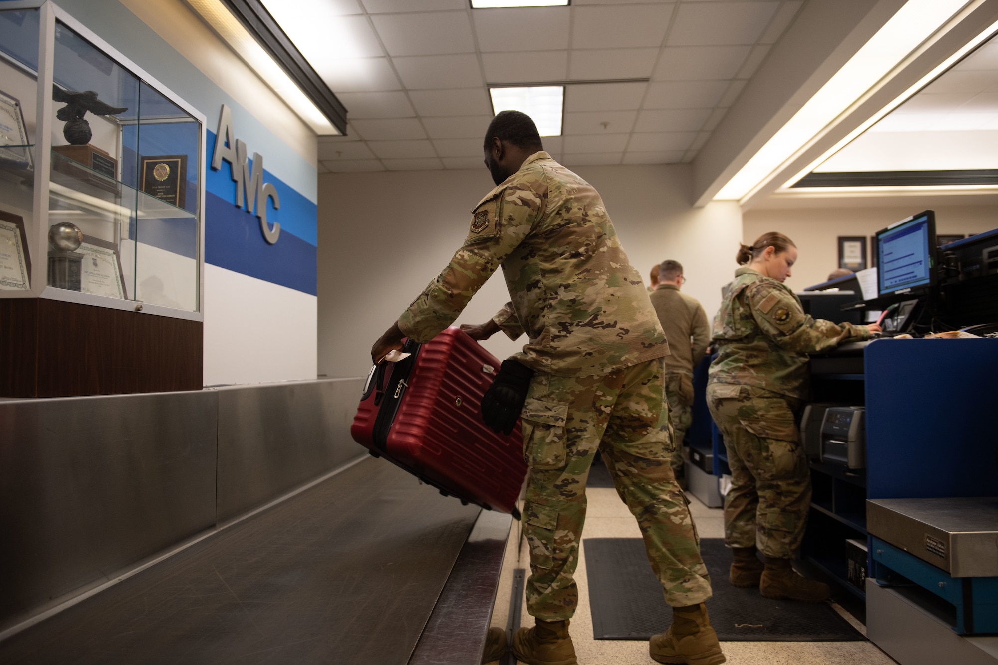 U.S. Air Force Senior Airman Jordan Williams, 436th Aerial Port Squadron Passenger Terminal passenger service representative, loads checked baggage onto the belt at the Passenger Terminal at Dover Air Force Base, Delaware, Mar. 8, 2025. At the 436th APS Passenger Terminal, active duty, reserve, guard, disabled veterans, retirees and their dependents can travel overseas on the C-5M Super Galaxy and the C-17 Globemaster III, at a low cost. (U.S. Air Force photo by Airman 1st Class Liberty Matthews)