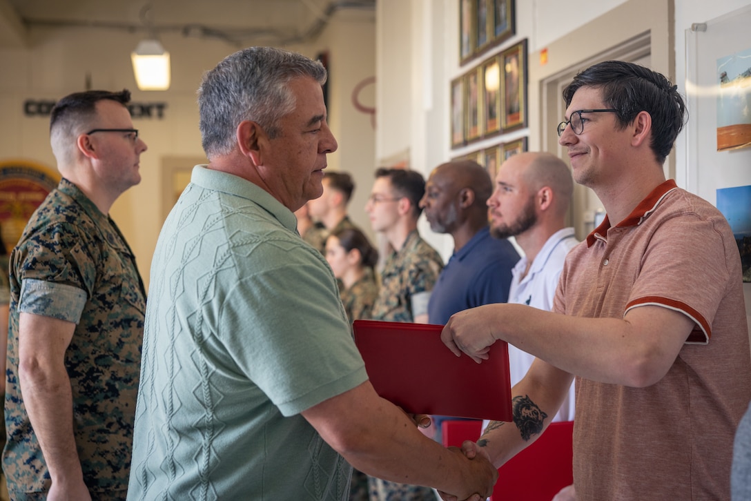 Tyler Harrison, lead videographer with Communication Strategy and Operations, Marine Corps Base Quantico, receives a certificate during an awards ceremony on MCB Quantico, Virginia, March 10, 2025. Several Marines and civilian Marines were awarded a Certificate of Appreciation due to their participation during the State Funeral of James Carter Jr., the 39th President of the United States. (U.S. Marine Corps photo by Lance Cpl. Joaquin Dela Torre)