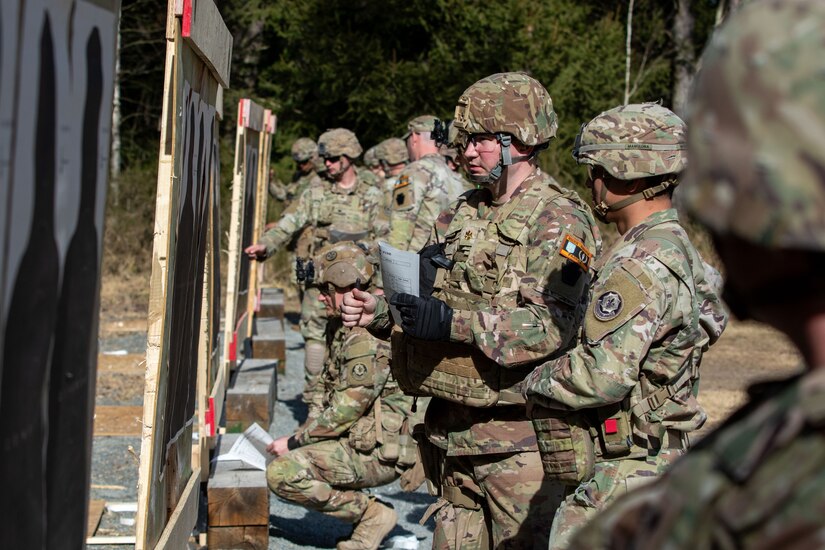 U.S. Soldiers inspect and grade their targets after engaging in an excellence-in-competition match at Grafenwoehr Training Area, Germany, March 9, 2025. The competition consisted of two events: a 30-yard slow fire match and a four-stage excellence-in-competition match whereby 10 percent of the top eligible competitors could earn career points toward the Distinguished Pistol Shot Badge. U.S. Soldiers with the 2nd Cavalry Regiment and the 7th Army Training Command joined the 56th Stryker Brigade Combat Team at the pistol competition, thus contributing to camaraderie among units, the opportunity to earn career points toward the Distinguished Pistol Shot Badge and improved readiness and lethality in marksmanship training. (U.S. Army National Guard photo by Capt. Leanne Demboski)