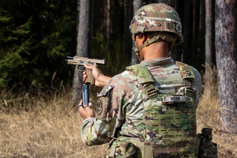 U.S. Army Spc. Tyler Webb, a computer/detection systems repairer with the 2nd Cavalry Regiment, changes his M17 pistol magazine during a standing stage of an excellence-in-competition match at Grafenwoehr Training Area, Germany, March 9, 2025. The competition consisted of two events: a 30-yard slow fire match and a four-stage excellence-in-competition match whereby 10 percent of the top eligible competitors could earn career points toward the Distinguished Pistol Shot Badge. U.S. Soldiers with 2CR and the 7th Army Training Command joined the 56th Stryker Brigade Combat Team at the pistol competition, thus contributing to camaraderie among units, the opportunity to earn career points toward the Distinguished Pistol Shot Badge and improved readiness and lethality in marksmanship training. (U.S. Army National Guard photo by Capt. Leanne Demboski)