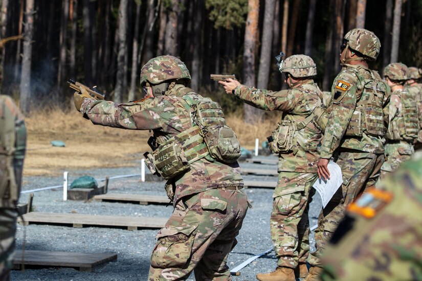 Firers stand and engage their targets during a pistol competition at Grafenwoehr Training Area, March 9, 2025. The competition consisted of two events: a 30-yard slow fire match and a four-stage excellence-in-competition match whereby 10 percent of the top eligible competitors could earn career points toward the Distinguished Pistol Shot Badge. U.S. Soldiers with the 2nd Cavalry Regiment and the 7th Army Training Command joined the 56th Stryker Brigade Combat Team at the pistol competition, thus contributing to camaraderie among units, the opportunity to earn career points toward the Distinguished Pistol Shot Badge and improved readiness and lethality in marksmanship training. (U.S. Army National Guard photo by Capt. Leanne Demboski)