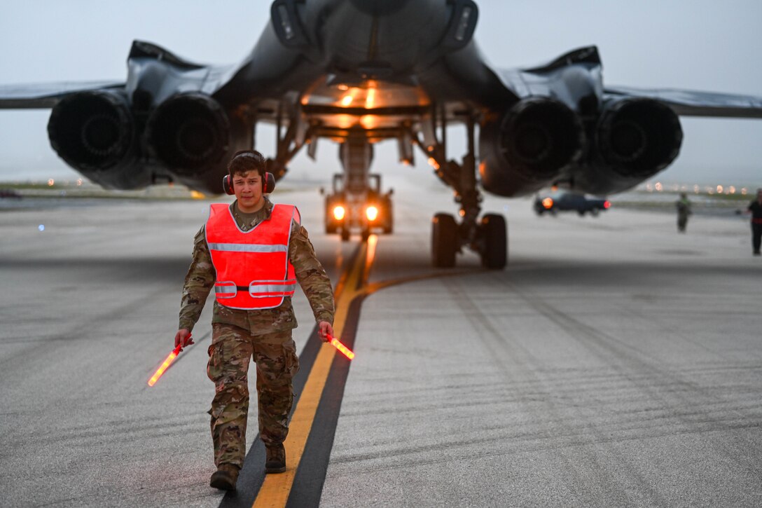 Airmen guides B-1B Lancer into a parking spot.