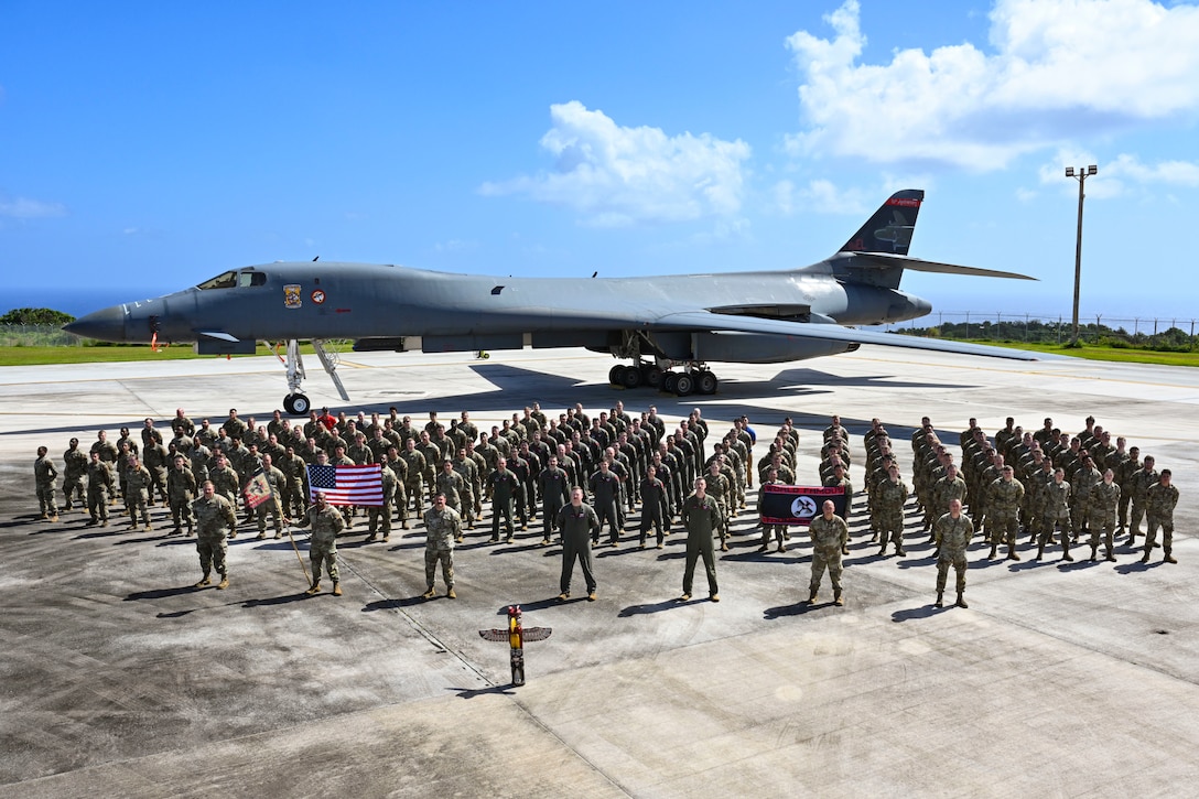 34th Expeditionary Bomb Squadron Airmen pose in front of a B-1B Lancer