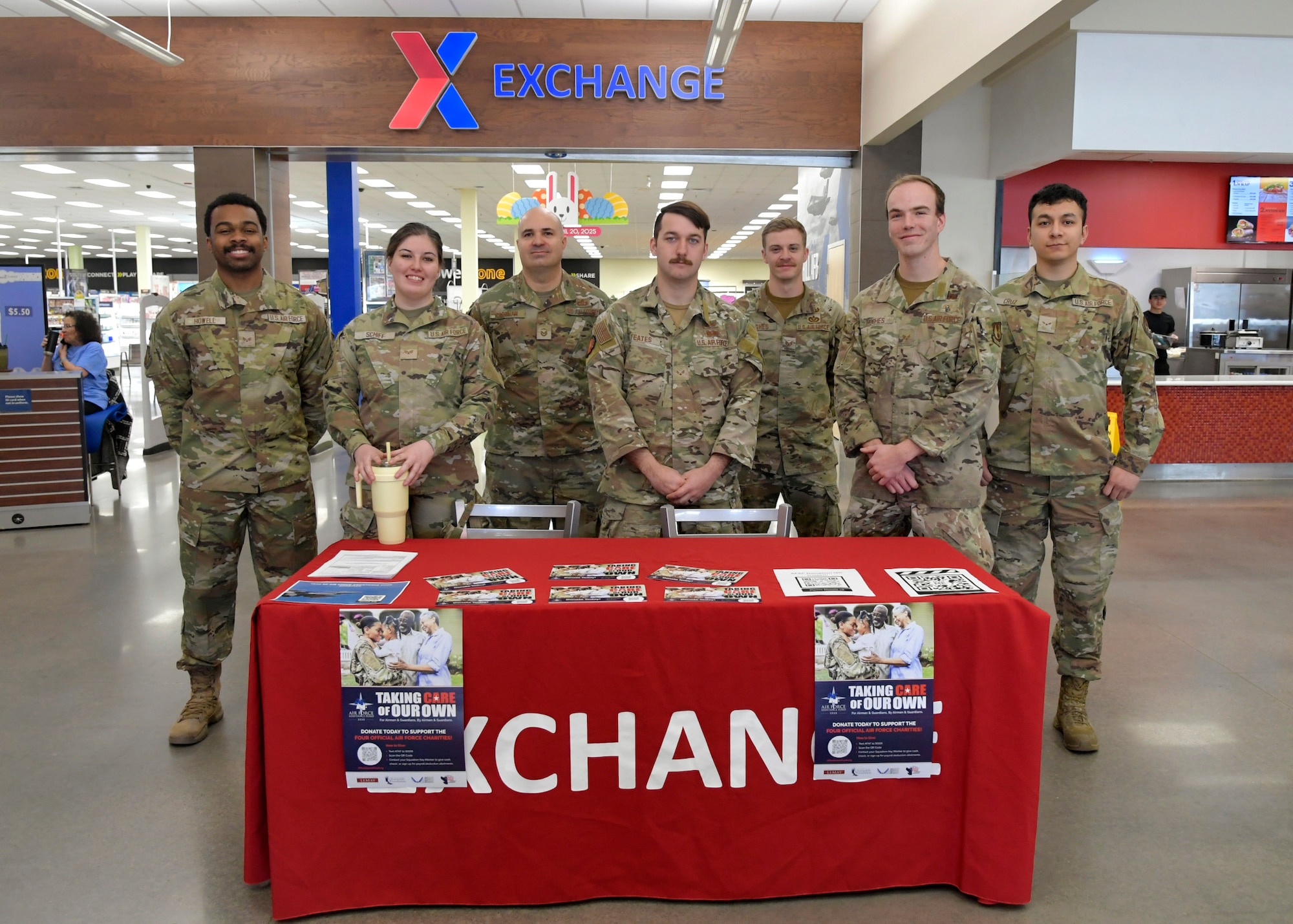 Airmen gather behind a table inside the AAFES Base Exchange.