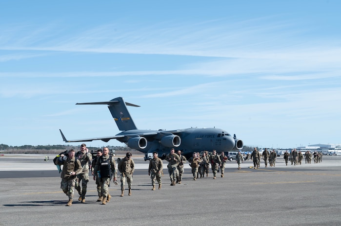 Airmen walk out of a C-17 Globemaster III cargo aircraft