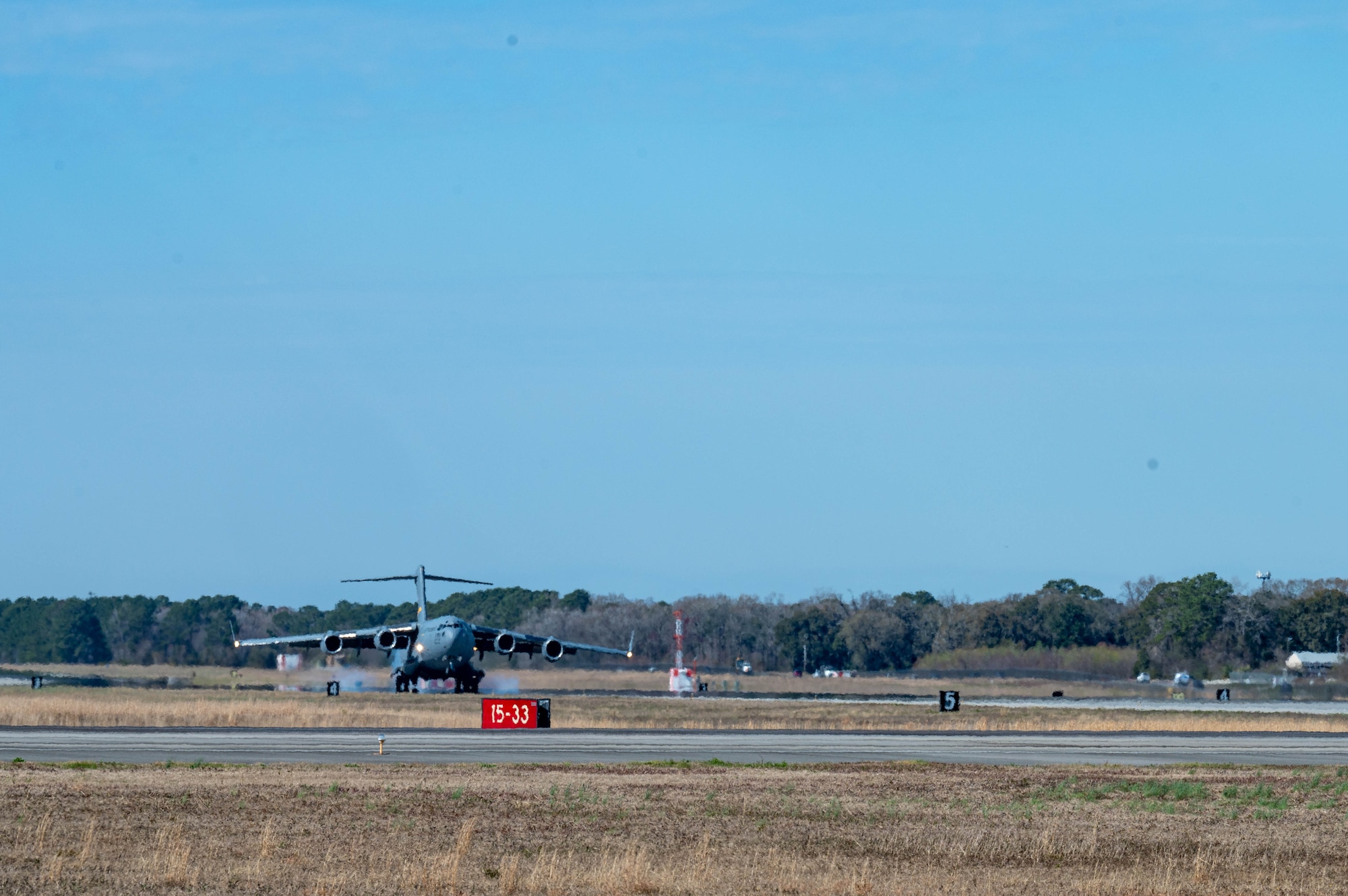 A C-17 Globemaster III cargo aircraft lands on an airfield