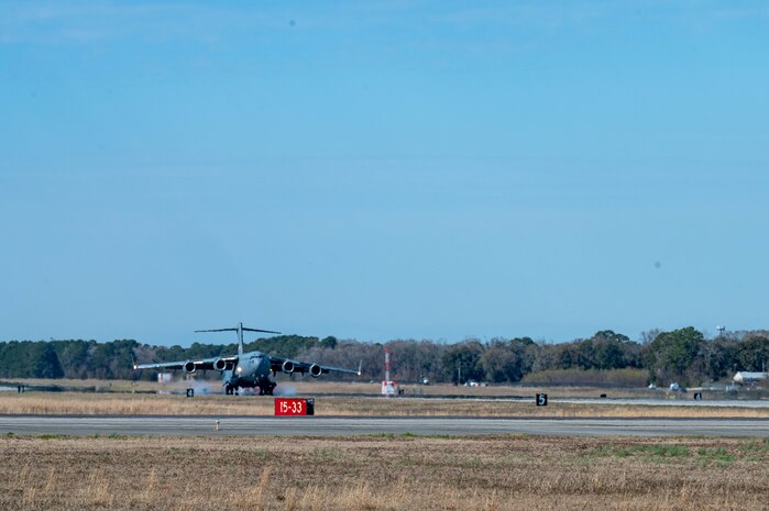 A C-17 Globemaster III cargo aircraft lands on an airfield