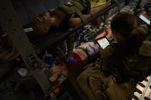 Airmen practice administering CPR to mannequin.