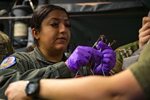 Airman simulates medical treatment on wingman.