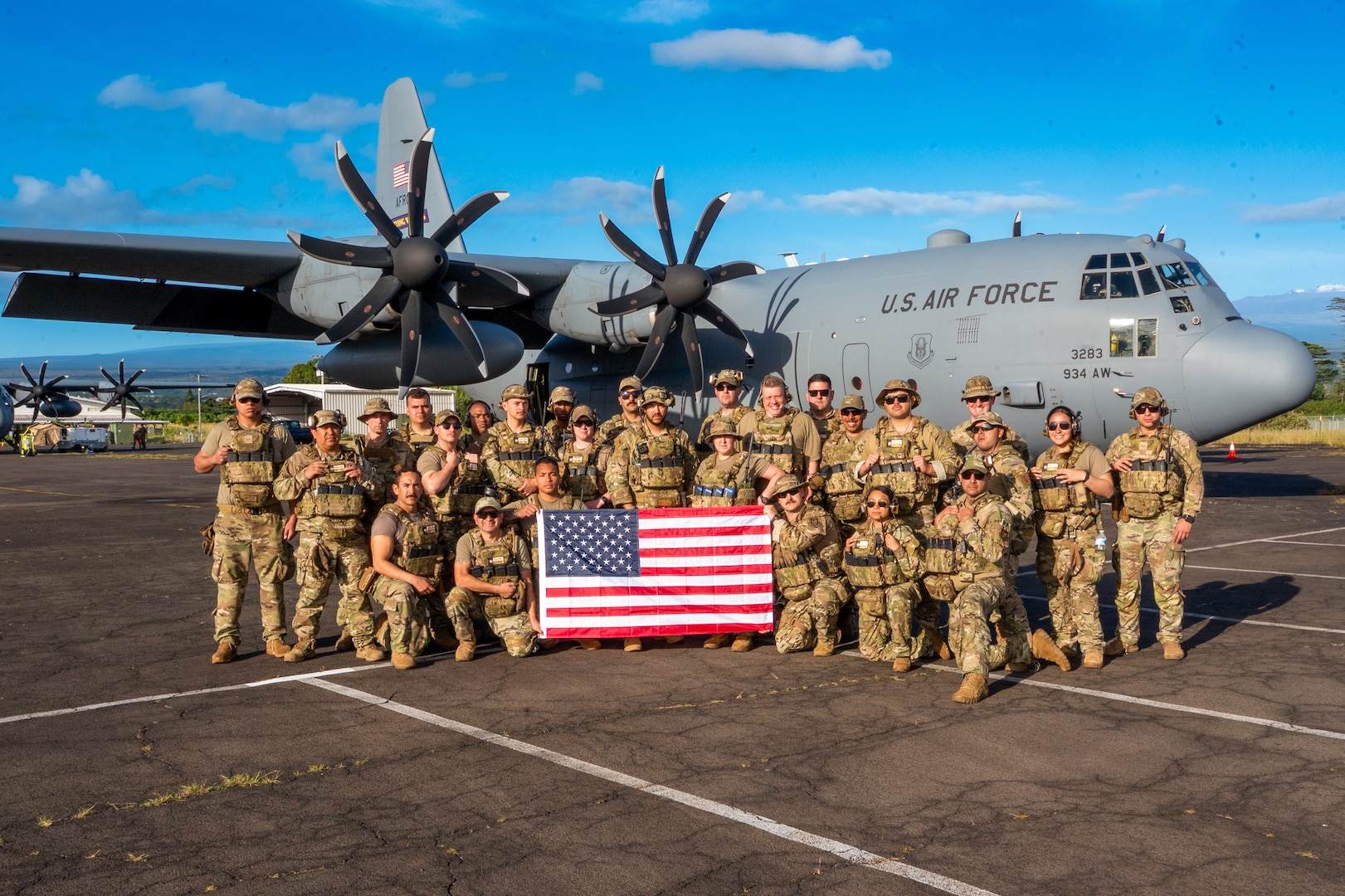 Airmen pose for a group photo with the U.S. flag