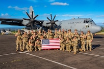 Airmen pose for a group photo with the U.S. flag