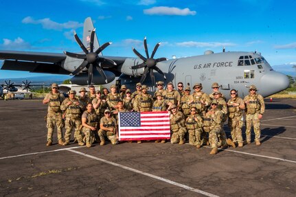 Airmen pose for a group photo with the U.S. flag
