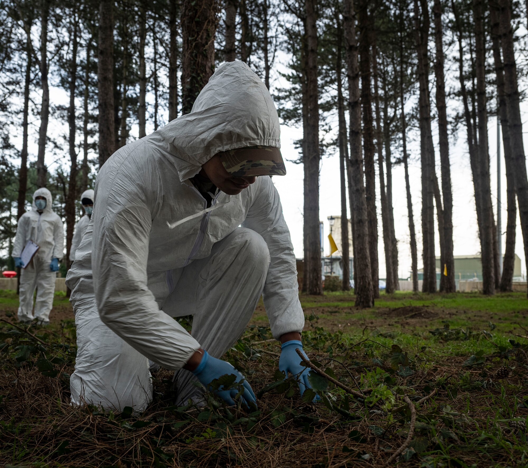 A U.S. Airman investigates debris during search and recovery training at RAF Mildenhall, England, Feb. 21, 2025.