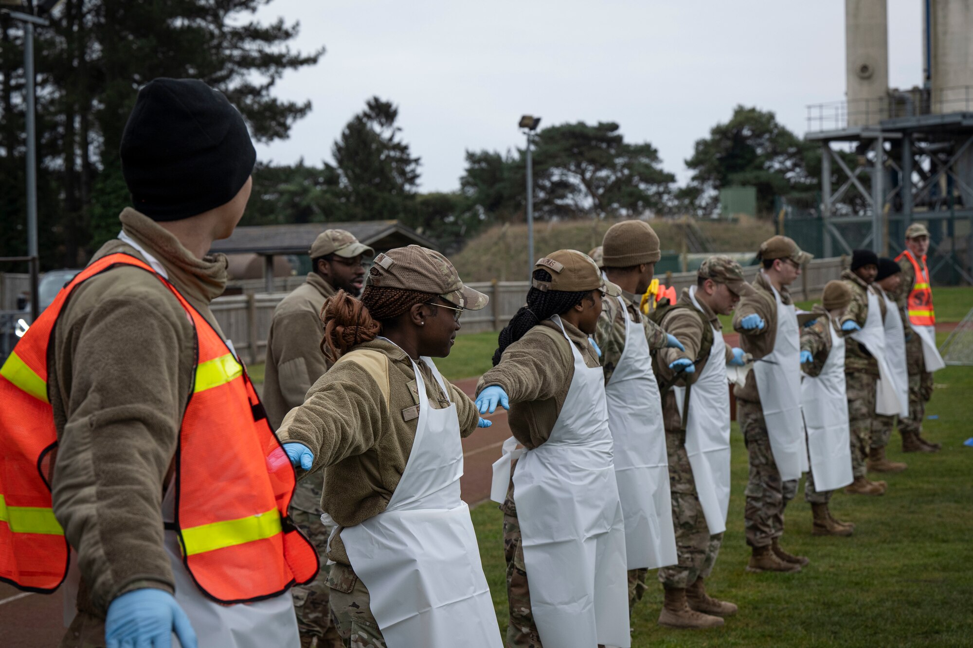 U.S. Airmen assigned to the 100th Force Support Squadron ready themselves in a line before searching for debris during a readiness exercise at RAF Mildenhall, England, Feb. 13, 2025.
