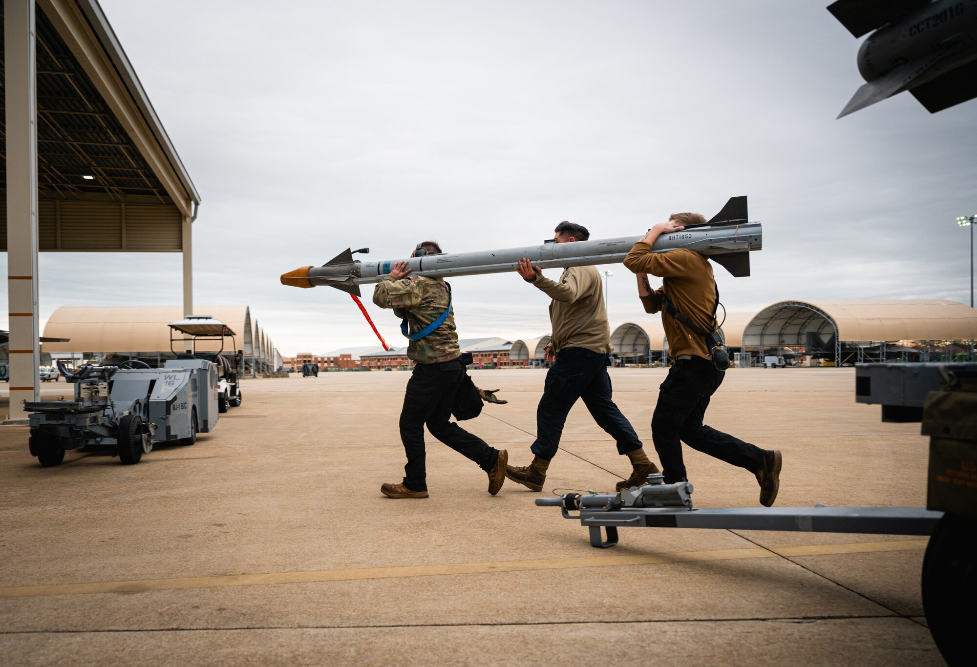 U.S. Airmen with the 94th Fighter Squadron, hurry to load an AIM-9 sidewinder during the Mitchell Trophy Air Race at Langley Air Force Base, Virginia, Mar. 6, 2025. The race increases lethality and combat resilience of those competing by testing physical and mental limitations. Events included a weapons load competition, a 1.5-mile run, and a flight from Virginia to Michigan and back, where pilots had to refuel their own F-22 Raptor.
(U.S. Air Force photo by Senior Airman Mikaela Smith)