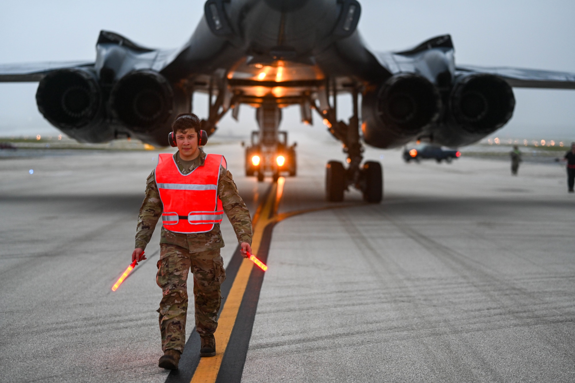 Airmen guides B-1B Lancer into a parking spot.