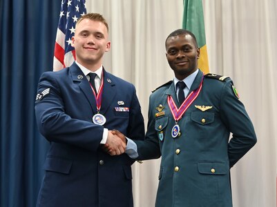 U.S. Air Force Senior Airman Trace Olson, left, North Dakota Air National Guard, and Benin air force Lt. Bertrand Zinsou, Cotonou, Benin, shake hands after graduation from Airman Leadership School Feb. 20, 2025, at the Paul H. Lankford Enlisted Professional Military Education Center, I.G. Brown Training and Education Center, McGhee Tyson Air National Guard Base, Tennessee.