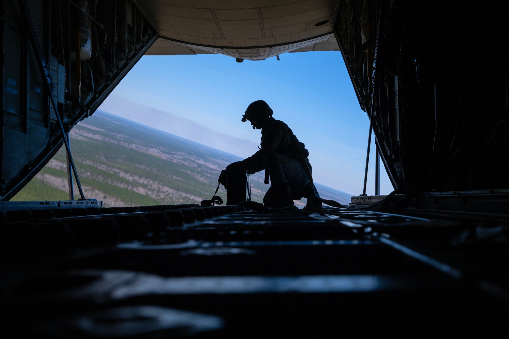 A loadmaster is preparing to drop a parabundle.