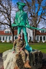 Spc. Rusha Adams, an information technology specialist with 1st Squadron, 303rd Cavalry Regiment, sits next to the Washington National Guard Minuteman Statue on Camp Murray, Wash., Feb. 26, 2025.