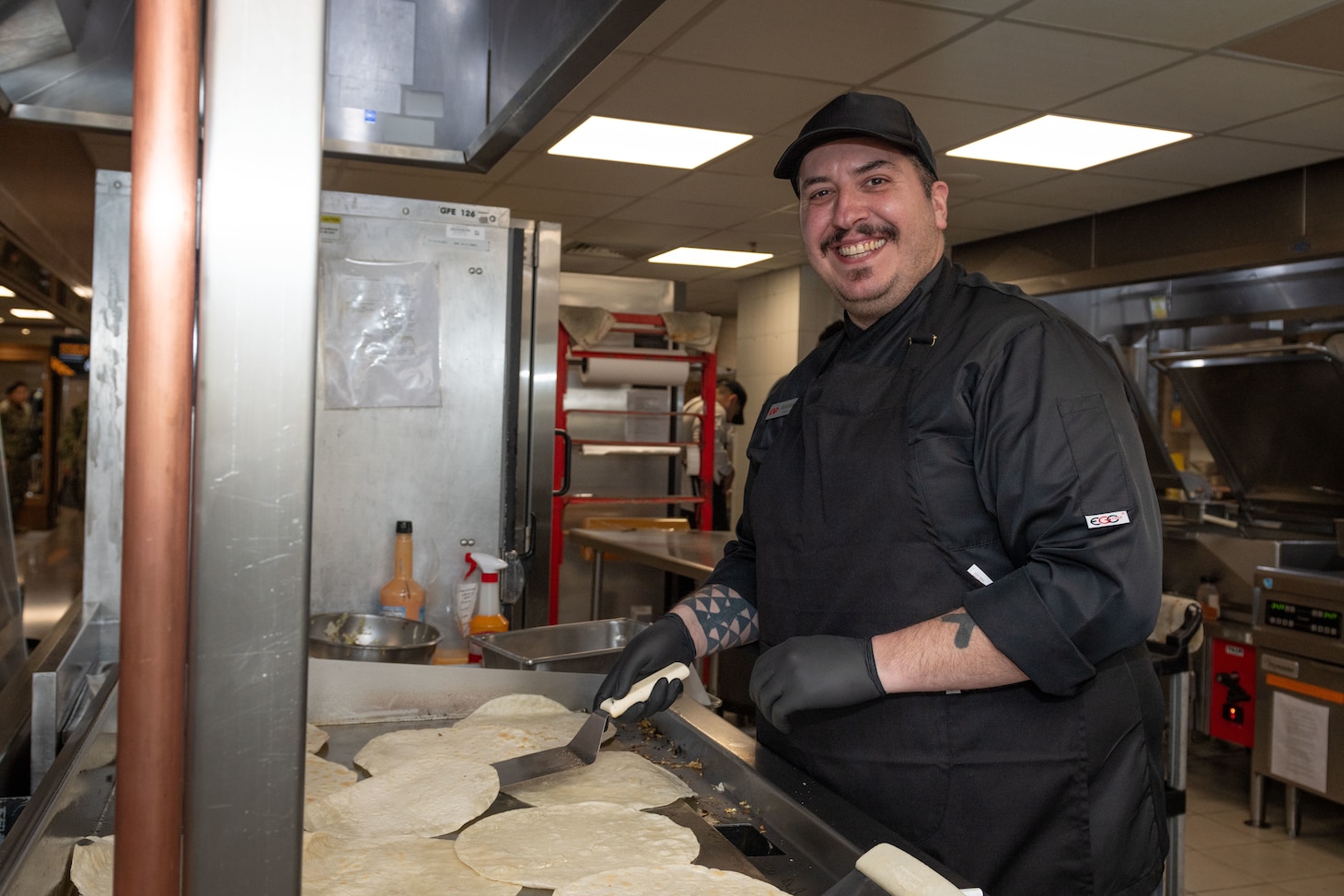 Cook Antonis Chatzigiannis, assigned to Naval Support Activity Souda Bay’s Minoan Taverna, toasts tortillas in the Minoan Taverna onboard NSA Souda Bay on March 11, 2025.