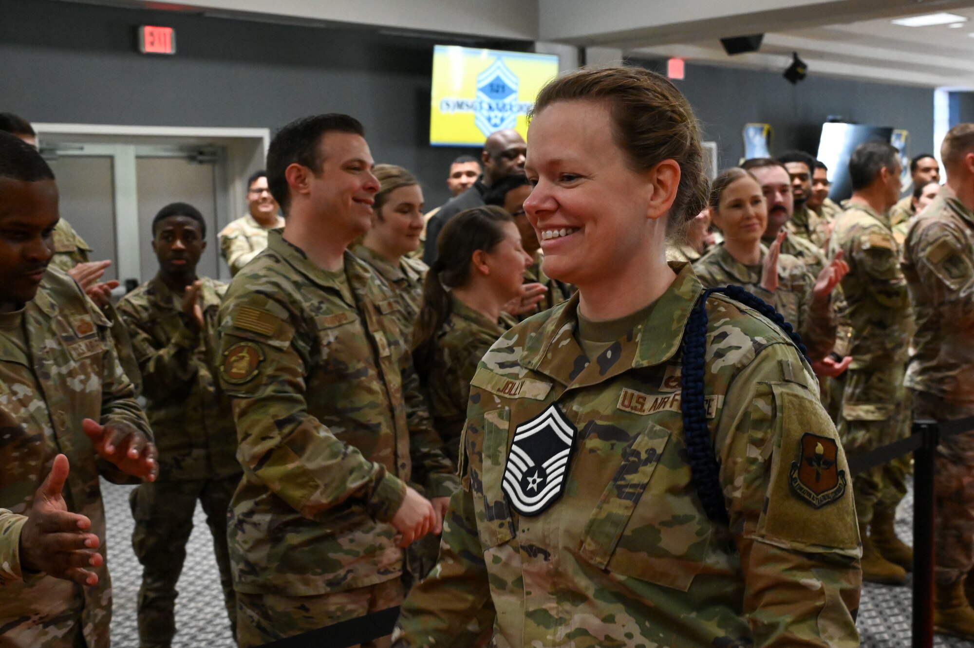 U.S. Air Force Senior Master Sgt. select Kara Jolly, 17th Training Group, walks the red carpet as she is cheered on by military personnel and attendees from the 17th Training Wing as part of the Senior Master Sergeant Release Party at the Powell Event Center, Goodfellow Air Force Base, Texas, March 10, 2025. As senior master sergeants, the selectees will apply their leadership and management skills throughout their careers as they prepare for expanded responsibilities and higher leadership roles. (U.S. Air Force photo by Airman 1st Class James Salellas)