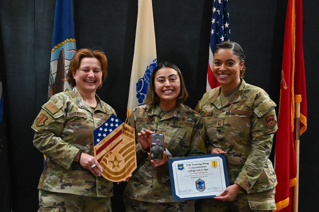 U.S. Air Force Senior Master Sgt. select Lesli Pape, 17th Training Wing Equal Opportunity, receives her line number virtually from Hickam Air Force Base, Hawaii, alongside Col. Angelina Maguinness, 17th Training Wing commander, Chief Master Sergeant Khamillia Washington, 17th TRW command chief, with the phone held by Master Sgt. Mary McCurdy, 17th Force Support Squadron first sergeant, at the Powell Event Center, Goodfellow Air Force Base, Texas, March 10, 2025. Out of the 17th Training Wing, five individuals were selected to sew on the rank of Senior Master Sgt. (U.S. Air Force photo by Airman 1st Class James Salellas)