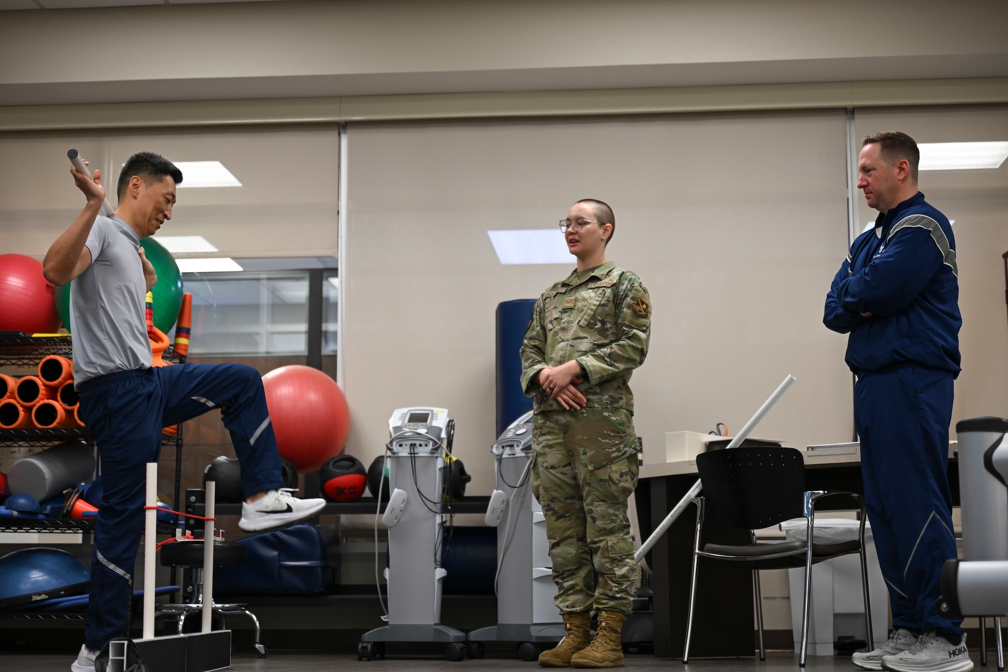 U.S. Air Force Col. Jun S. Oh, 316th Wing and installation commander, performs a functional movement screening as part of the “Winnin’ Like a Griffin” initiative at Joint Base Andrews, Md., Feb. 26, 2024. Senior Airman Mathilde French-Elliott, a physical medicine technician with the 316th Operational Medical Readiness Squadron, guided Oh through the screening process while Chief Master Sgt. Kevin W. Helms, 316th Wing command chief, observed.