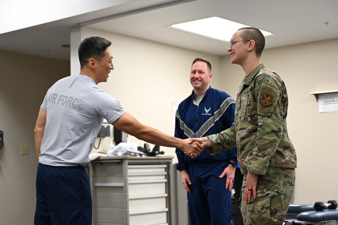 U.S. Air Force Col. Jun S. Oh, 316th Wing and installation commander, shakes hands with Senior Airman Mathilde French-Elliott, a physical medicine technician with the 316th Operational Medical Readiness Squadron, after presenting her with a coin for outstanding performance at Joint Base Andrews, Md., Feb. 26, 2024. The 316th Wing leadership recognized French-Elliott as part of the “Winnin’ Like a Griffin” initiative, which highlights Airmen for their contributions to the mission.