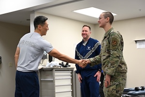 U.S. Air Force Col. Jun S. Oh, 316th Wing and installation commander, shakes hands with Senior Airman Mathilde French-Elliott, a physical medicine technician with the 316th Operational Medical Readiness Squadron, after presenting her with a coin for outstanding performance at Joint Base Andrews, Md., Feb. 26, 2024. The 316th Wing leadership recognized French-Elliott as part of the “Winnin’ Like a Griffin” initiative, which highlights Airmen for their contributions to the mission. (U.S. Air Force photo by Senior Airman Gianluca Ciccopiedi)