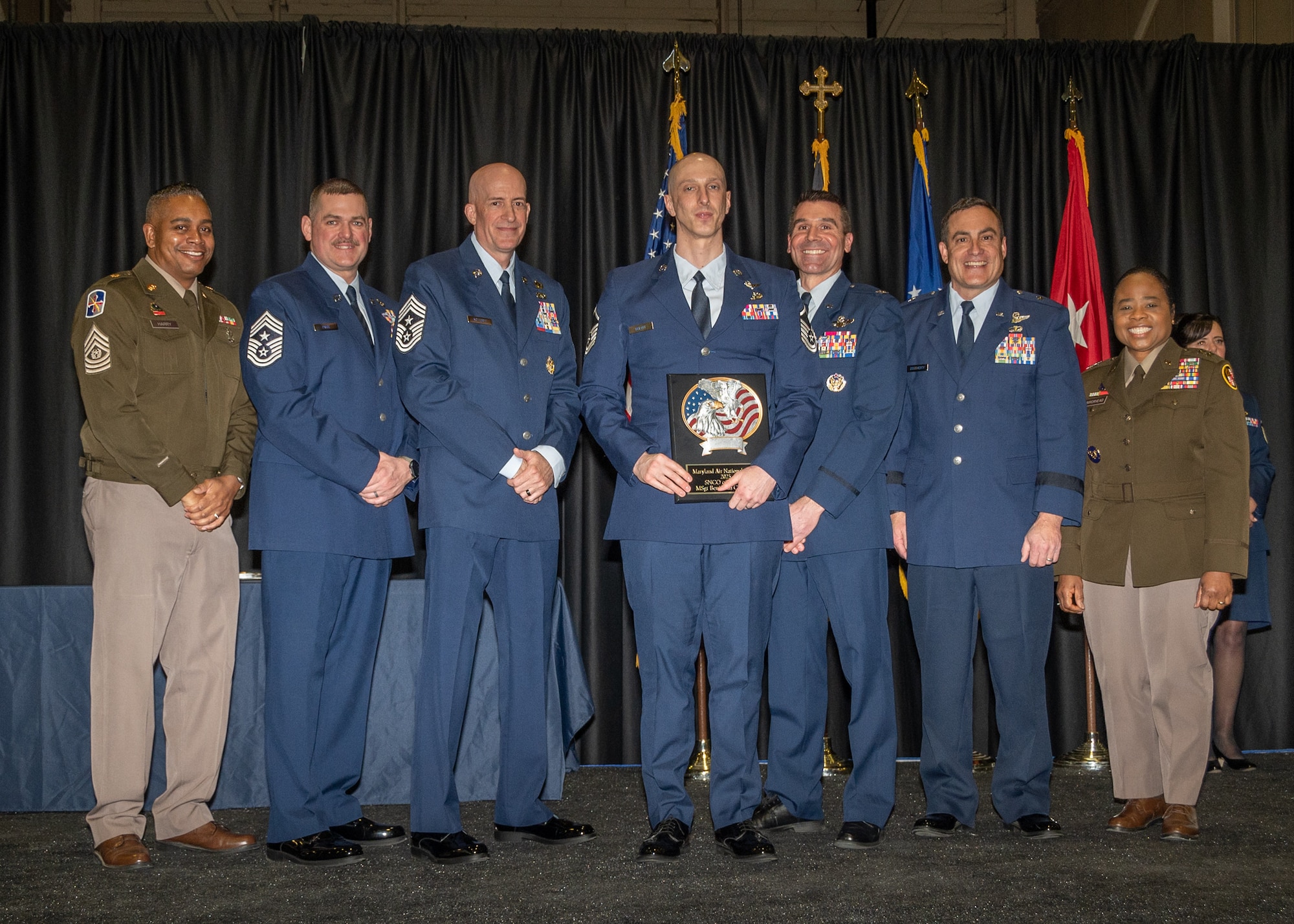 Maryland Air National Guard Master Sgt. Benjamin Koloff, 175th Cyber Operation Squadron, senior non-commissioned officer of the year, receives a plaque during the 175th Wing’s Airman Recognition Ceremony at Warfield Air National Guard Base at Martin State Airport, Maryland, January 12, 2025.