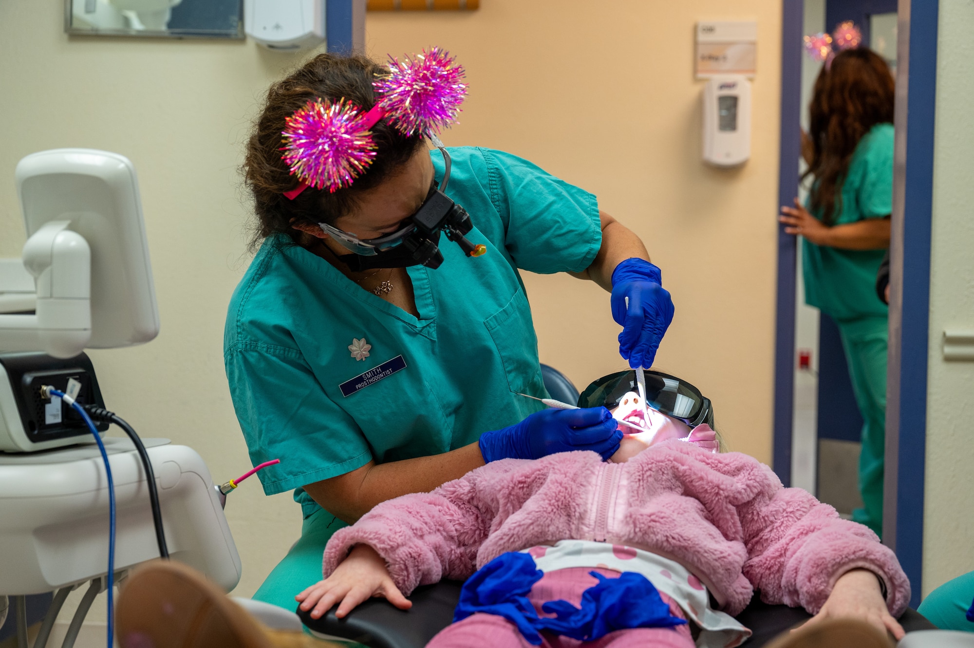 Lt. Col. Nicole Smith a prosthodontist, cleans a young patient’s teeth.