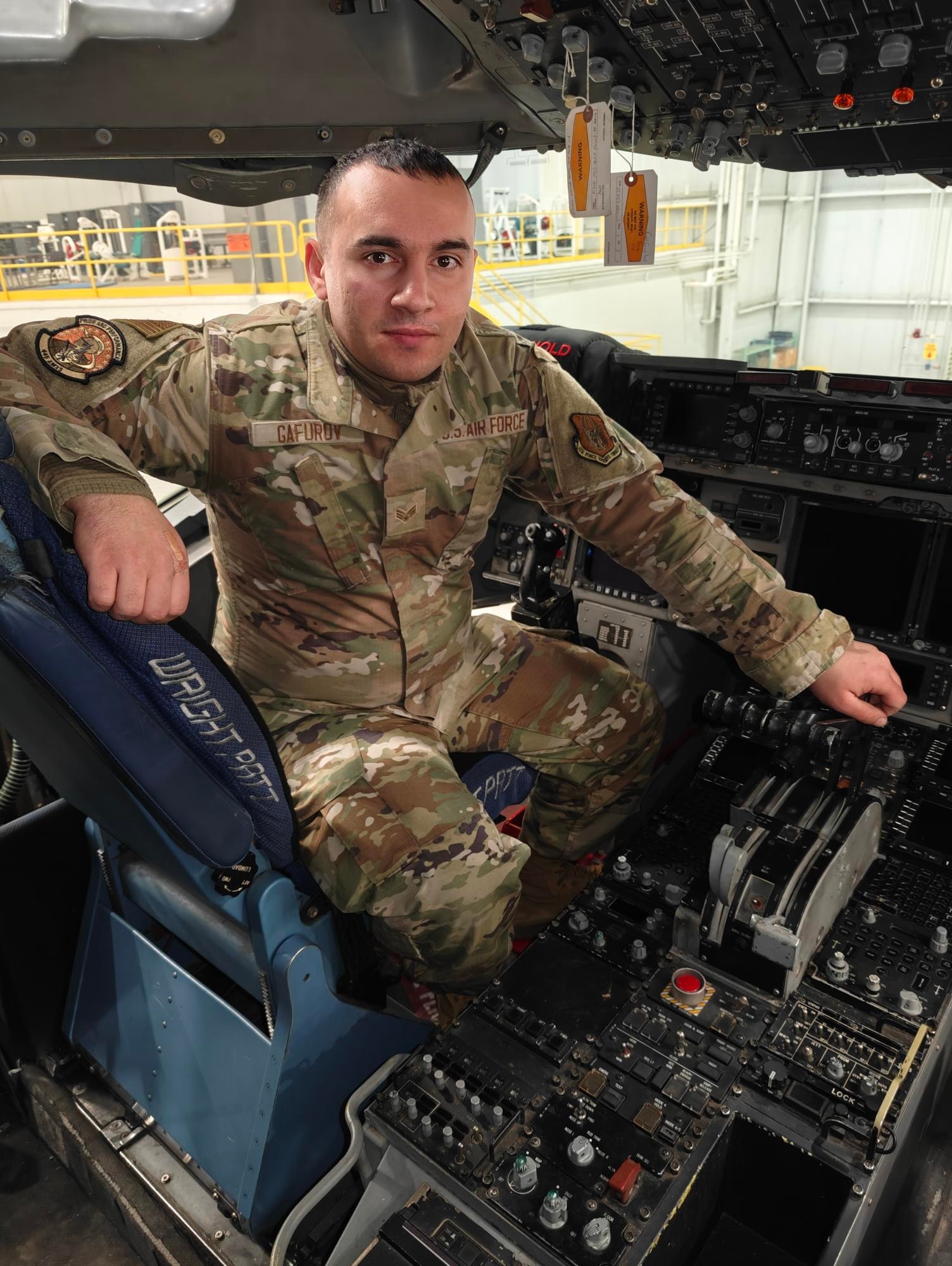 Senior Airman Salchuk A. Gafurov Sr., 445th Aircraft Maintenance Squadron integrated avionics technician, poses for a photo on the flight deck of a C-17 Globemaster III at Wright- Patterson Air Force Base.