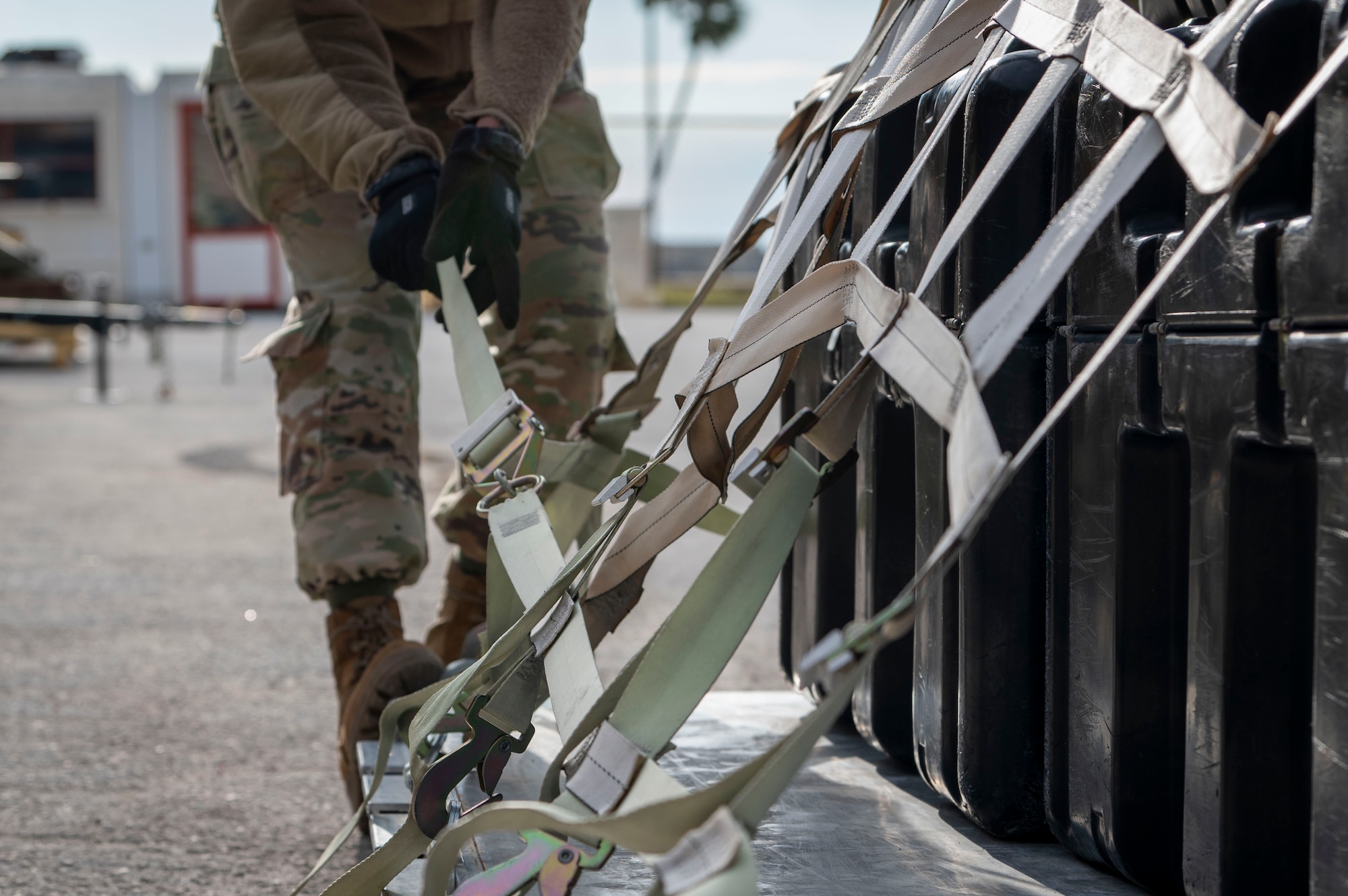 A U.S. Air Force Airman assigned to the 6th Air Refueling Wing adjusts the strap on a cargo pallet during increment monitor training.