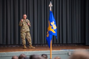 Maj. Gen. Bartrum speaks on stage to the 349th Medical Group in the base theatre.