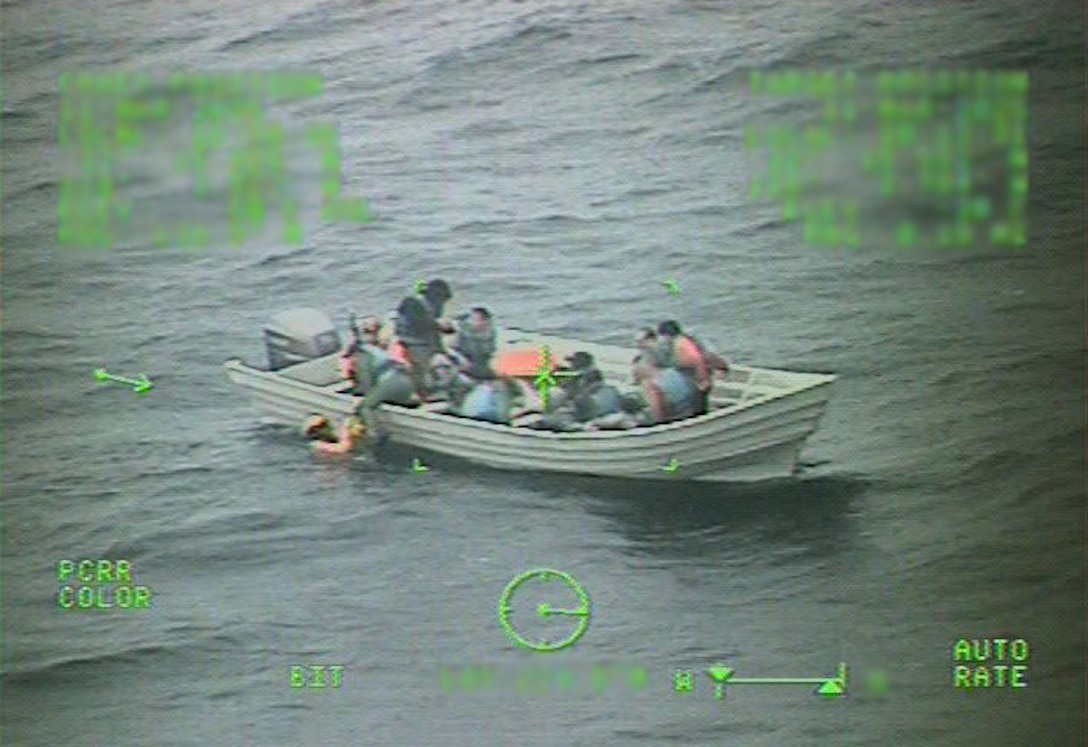 Visual from camera onboard MH-60 Jayhawk helicopter showing the rescue swimmers assisting the aliens aboard the disabled vessel.