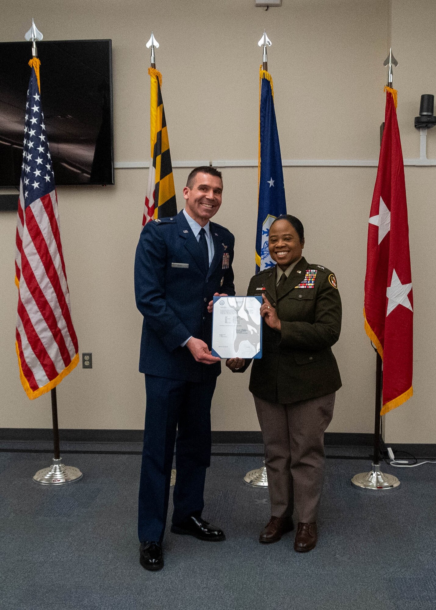 Maryland Army National Guard Maj. Gen. Janeen Birckhead, adjutant general for Maryland, presents a certificate of promotion to Maryland Air National Guard Col. Richard D. Hunt, commander of the 175th Wing, during a ceremony at Warfield Air National Guard Base at Martin State Airport, February 28, 2025.