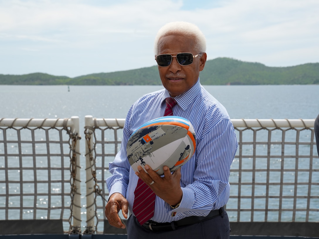 Sir Arnold Amet, the Papua New Guinea Ambassador to the United States, holds a rugby ball on the flight deck of the Coast Guard Cutter Midgett (WMSL 757) Mar. 6, 2025. The U.S. Coast Guard supports deepening and expanding its bilateral relationship with Papua New Guinea. (U.S. Coast Guard photo by Petty Officer 3rd Class Jennifer Nilson)