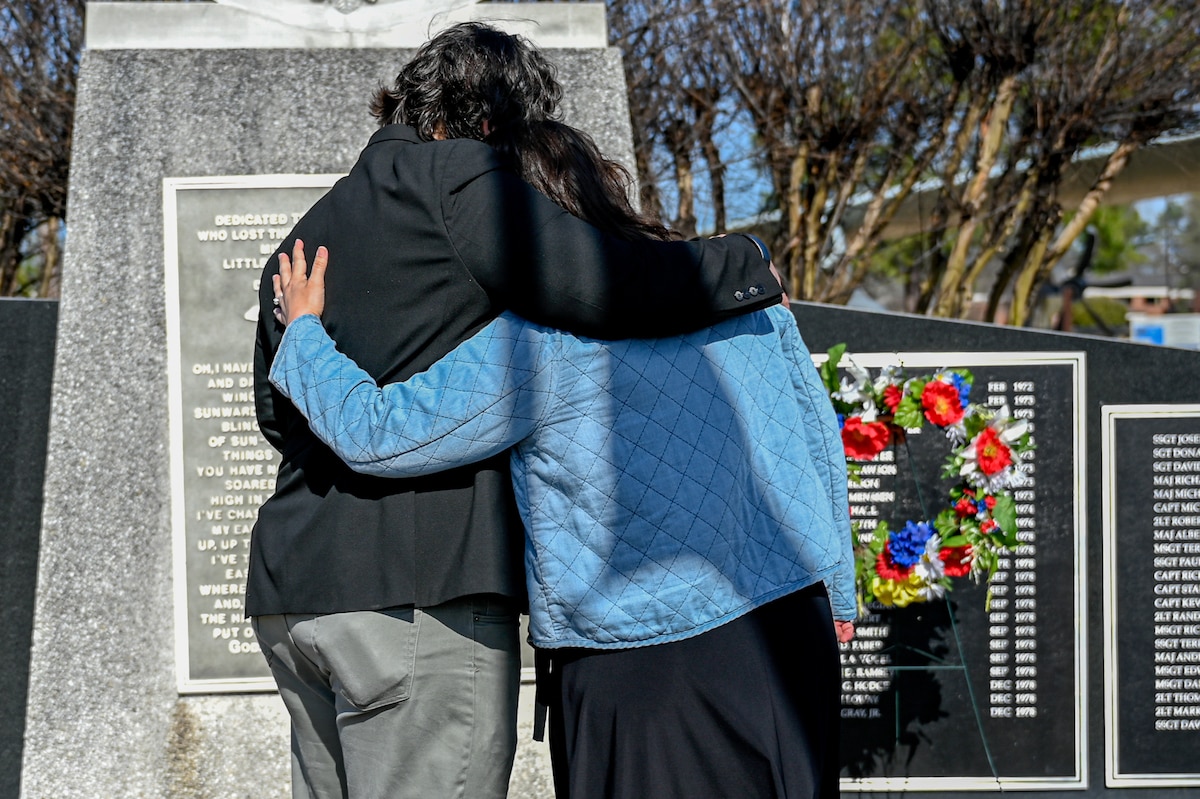 Family members hug in front of the High Flight Memorial during a remembrance ceremony at Little Rock Air Force Base, Arkansas, March 12, 2025. The 314th Airlift Wing hosted the ceremony to commemorate the 40th anniversary of a tragic C-130E Hercules accident which took the lives of six Airmen.