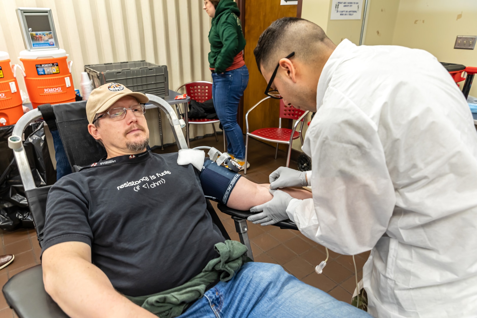 Staff Sgt. Yoseph Roman, medic, Company C, Madigan Army Medical Center, collects blood from Patrick McIlhaga, electronics instructor, Shop 67, Electronics Technicians, March 5, 2025, during the monthly Blood Drive at Puget Sound Naval Shipyard & Intermediate Maintenance Facility in Bremerton, Washington. (U.S. Navy photo by Ben Hutto)