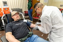Staff Sgt. Yoseph Roman, medic, Company C, Madigan Army Medical Center, collects blood from Patrick McIlhaga, electronics instructor, Shop 67, Electronics Technicians, March 5, 2025, during the monthly Blood Drive at Puget Sound Naval Shipyard & Intermediate Maintenance Facility in Bremerton, Washington. (U.S. Navy photo by Ben Hutto)