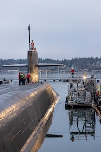 Crew members stand topside as USS Ohio (SSGN 726) prepares to depart from Pier 5 at Puget Sound Naval Shipyard & Intermediate Maintenance Facility in Bremerton, Washington, Dec 19, 2025, as it transitioned to its final stage of testing and crew certification. (U.S. Navy photo by Wendy Hallmark)