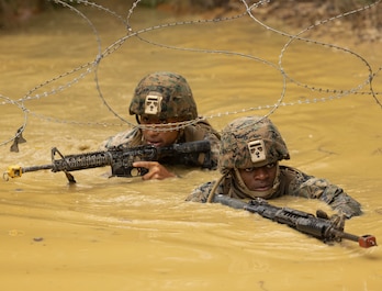 OKINAWA, Japan (March 6, 2025) — U.S. Marine Corps 2nd Lt. Taiyo Tatara, left, a communication strategy and operations officer with 3rd Marine Logistics Group (3rd MLG), and Cpl. Ekwili Ekpo, right, a food service specialist with Combat Logistics Regiment 37, 3rd MLG, traverse through water during a Basic Jungle Skills Course at Jungle Warfare Training Center, Camp Gonsalves, Okinawa, Japan, March. 7, 2025. Tatara is a native of Japan. Ekpo is a native of Texas. The course is designed to sharpen the Marines' ability to operate effectively in harsh, unfamiliar terrain, preparing them to confront adversaries in any environment, ensuring they remain agile and combat-ready in the face of evolving threats. (U.S. Marine Corps photo by Lance Cpl. Weston Brown)