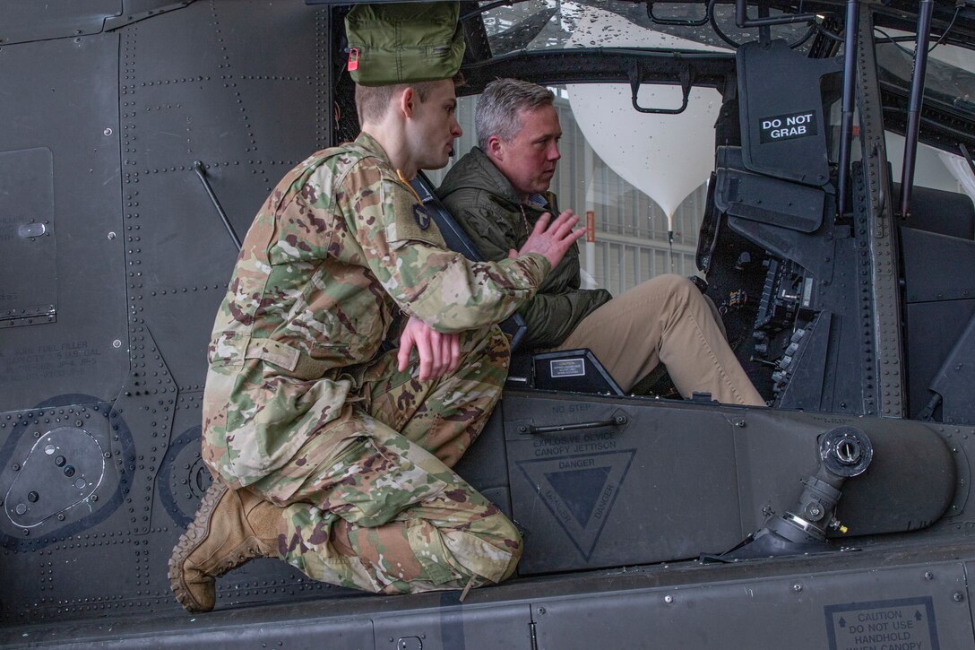 Capt. Brandon Rasor of the 16th Combat Aviation Brigade, 7th Infantry Division, shows the interior of the AH-64 Apache cockpit to the Honorable Dan Driscoll, the 26th Secretary of the Army, at Joint Base Lewis-McChord, Washington, on March 10, 2025.