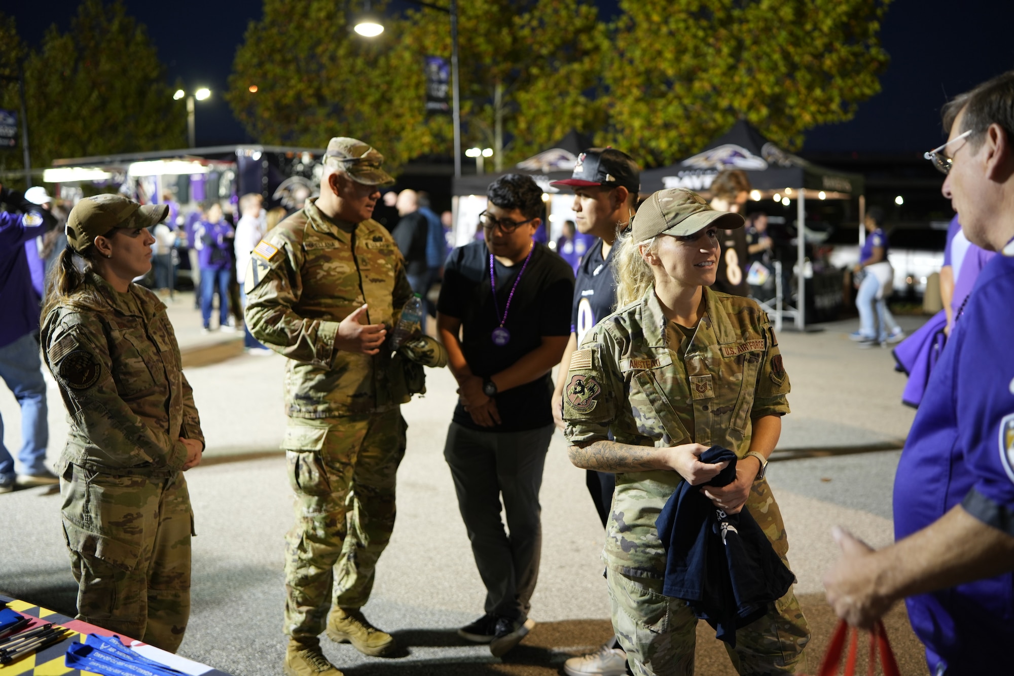 Two Maryland Air National Guard recruiters from the 175th Wing speak to attendees at a booth outside the M&T Bank Stadium before a Baltimore Ravens NFL game in Baltimore, Maryland, November 7, 2024.