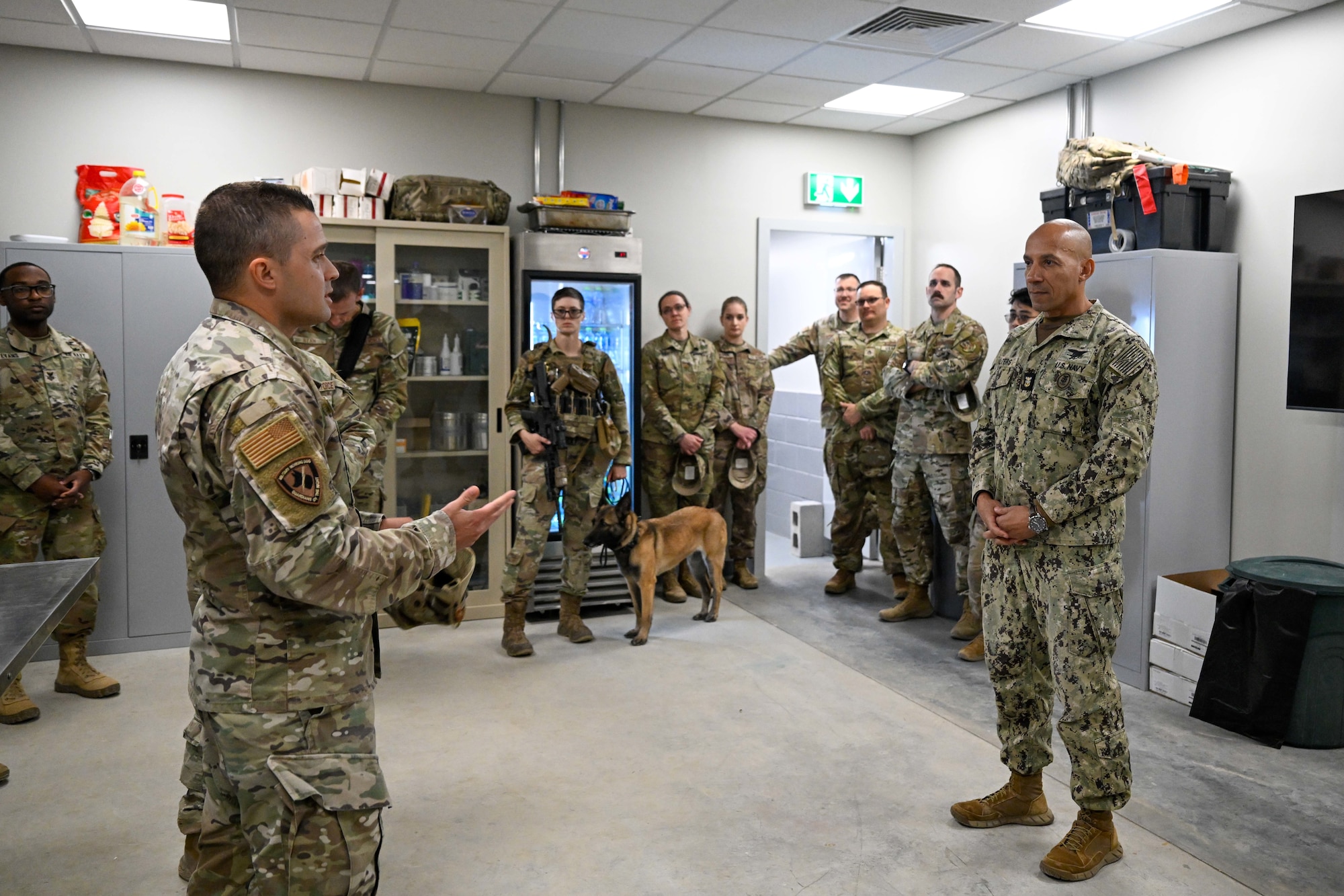 A group of military members talk together inside.